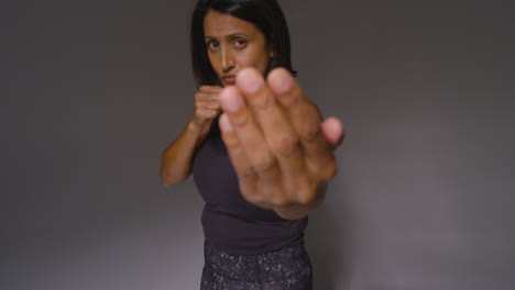 Studio-Portrait-Of-Mature-Woman-Wearing-Gym-Fitness-Clothing-Exercising-Sparring-At-Camera-3